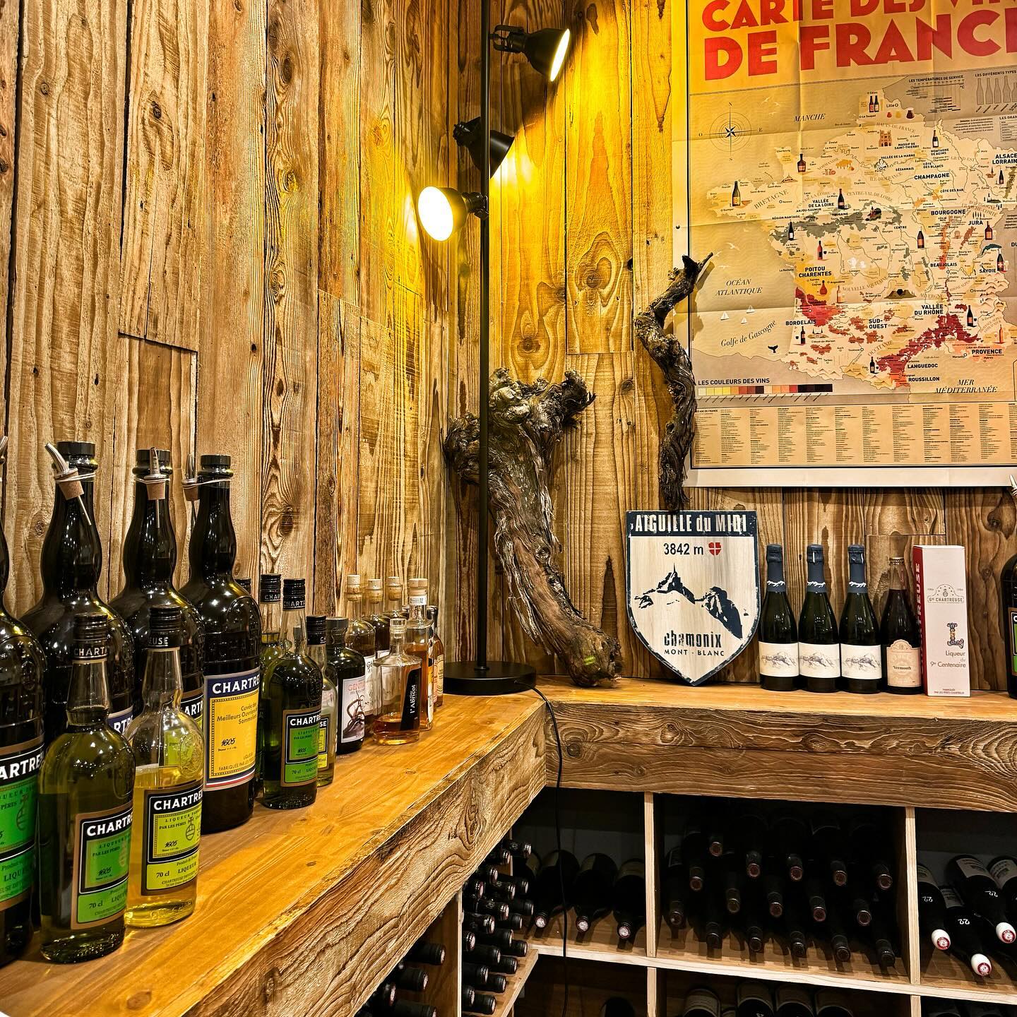 Intérieur en bois du Bistrot, collection de Chartreuse et carte des vins de France
