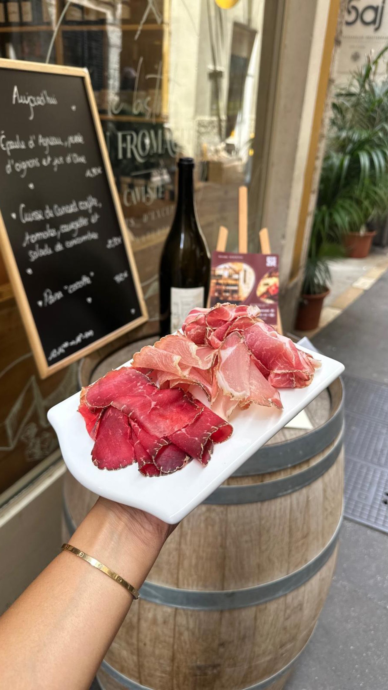 La planche de charcuterie tranchée minute, servie sur le tonneau devant l'ardoise