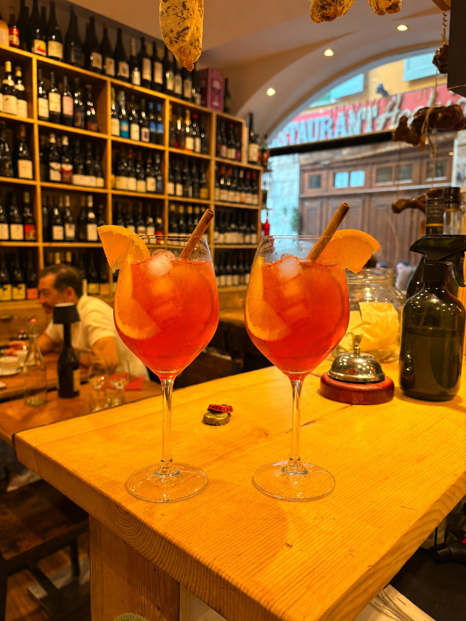 Deux Aperol Spritz au comptoir du Bistrot du Fromager, mur de vins en fond
