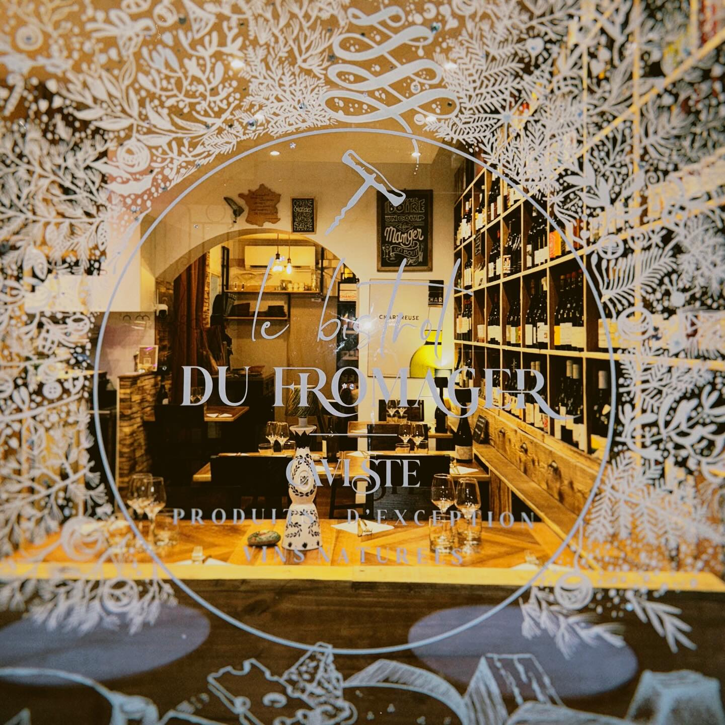 La vitrine gravée du Bistrot du Fromager, la salle et la cave en fond